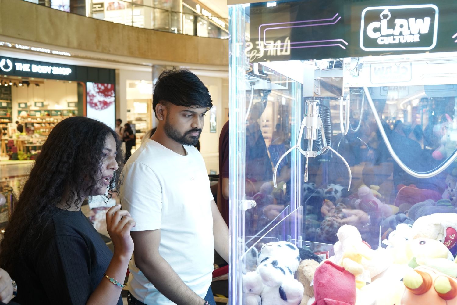 People enjoying a claw machine game together inside Claw Culture