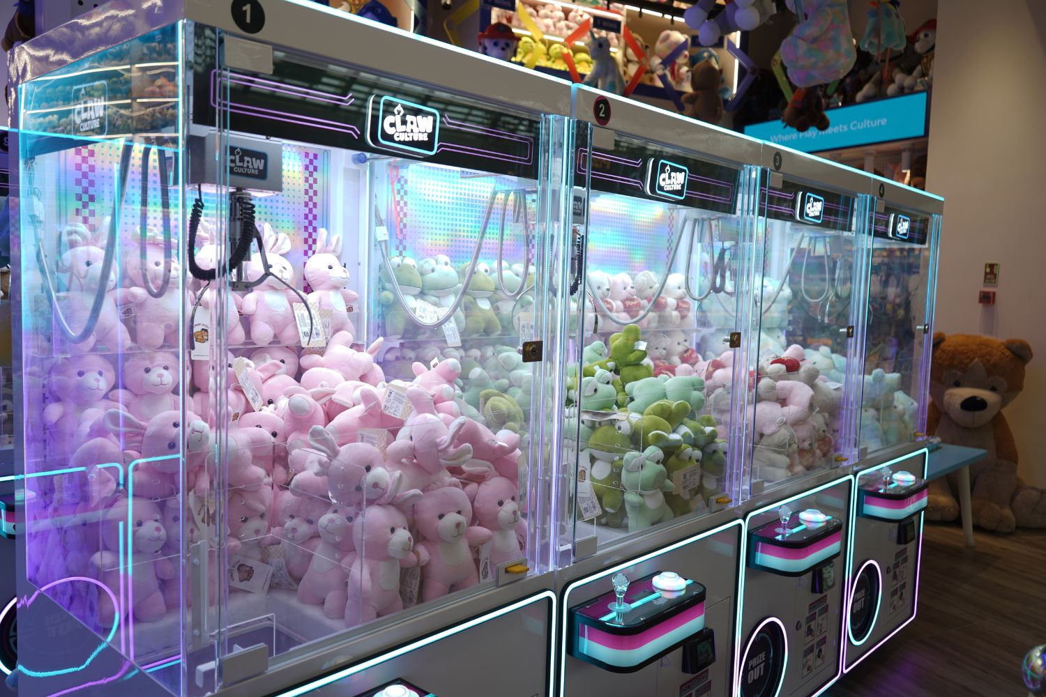 Rows of claw machines filled with plush toys at Claw Culture